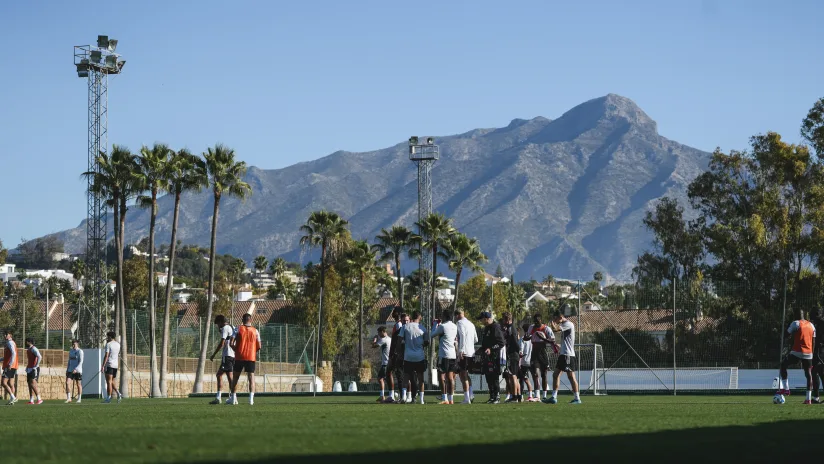 Squad gathered on a Marbella training pitch with La Concha mountain backdrop at the Aurora Football Showcase