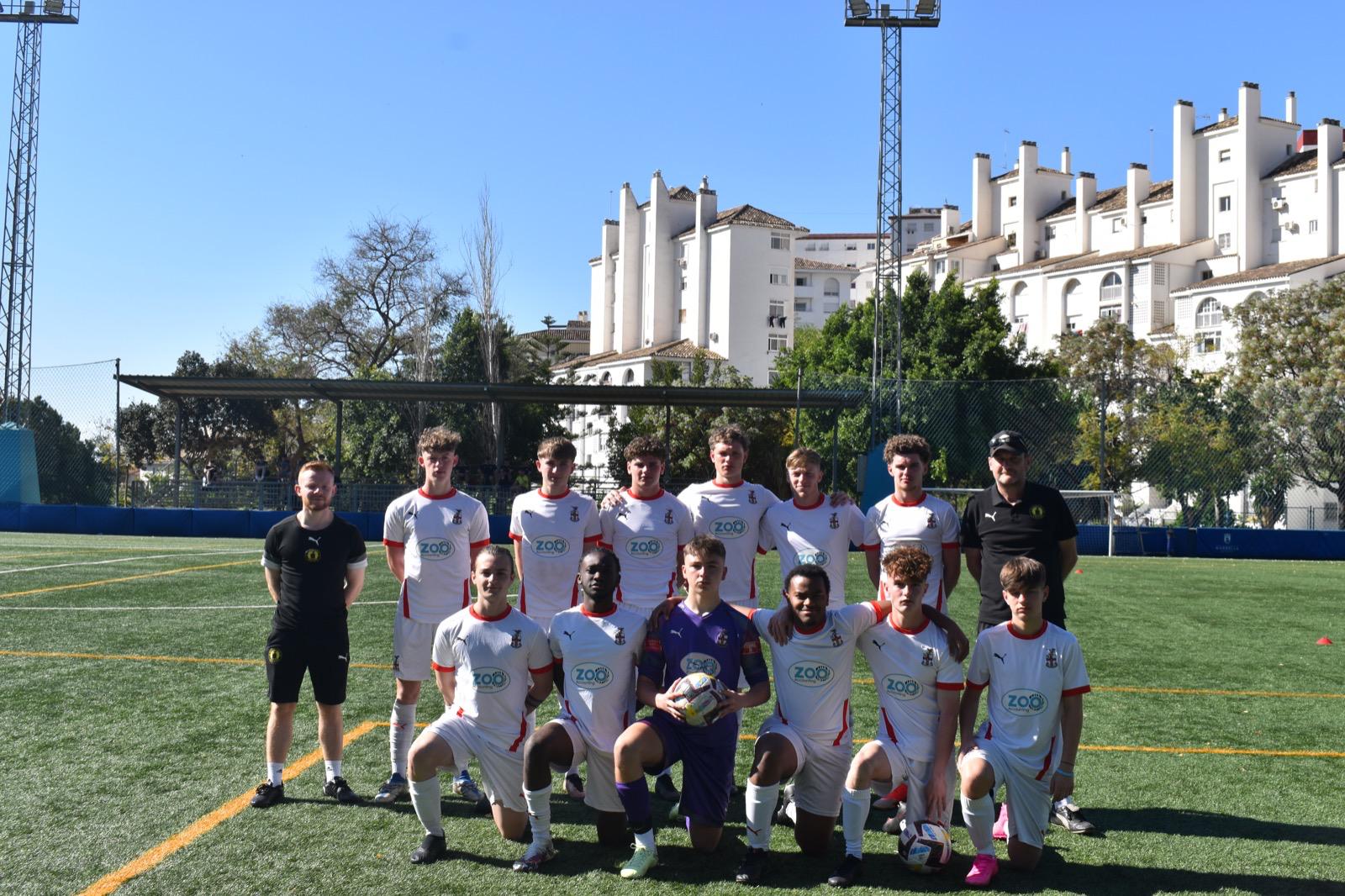 Redditch United squad lined up for a team photo on a Marbella pitch during their Easter football tour