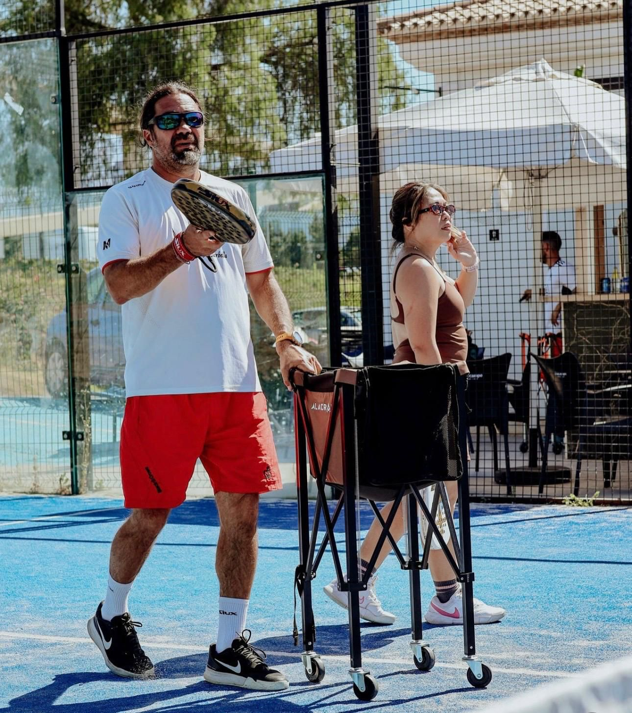 Aurora Padel Clinic coach demonstrating with paddle on court in Marbella